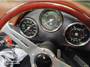 Sitting is a Porsche, looking at the gorgeous dashboard.